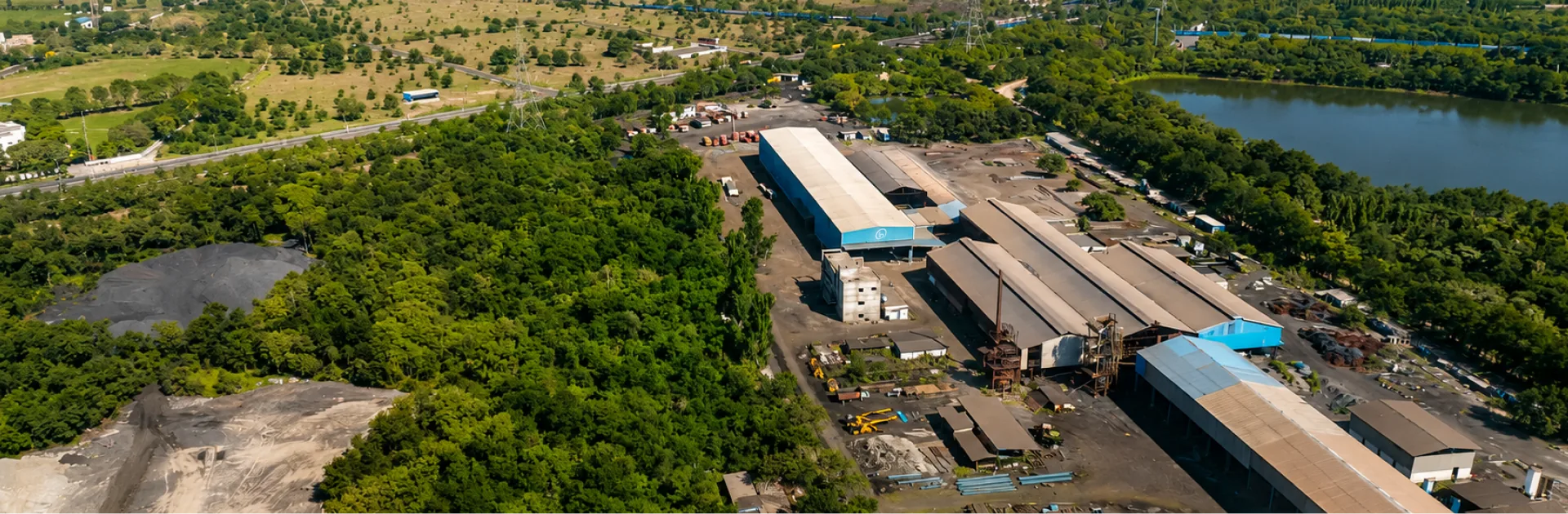 Aerial view of a riverside OfBusiness manufacturing facility